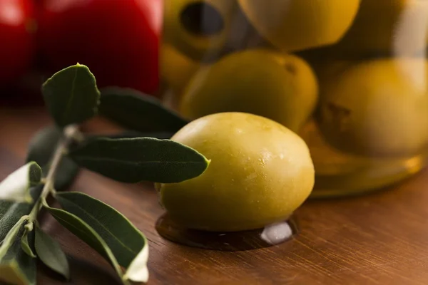Pickled olives and olive tree branch — Stock Photo, Image