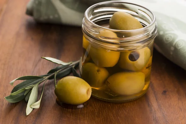 Pickled olives and olive tree branch — Stock Photo, Image