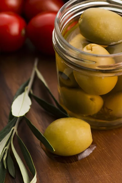 Pickled olives and olive tree branch — Stock Photo, Image