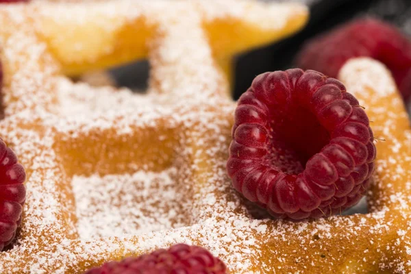 Frische Waffeln garniert mit Puderzucker und Himbeeren — Stockfoto