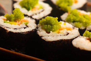 Somon ve yeşil Wasabi havyarlı California suşi ruloları.