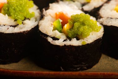 Somon ve yeşil Wasabi havyarlı California suşi ruloları.