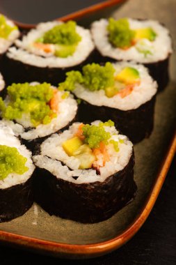 Somon ve yeşil Wasabi havyarlı California suşi ruloları.