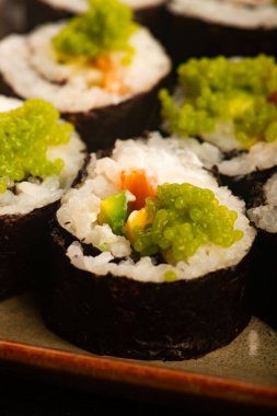 Somon ve yeşil Wasabi havyarlı California suşi ruloları.