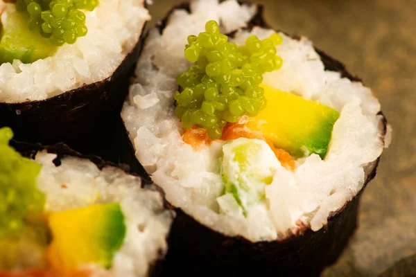 Somon ve yeşil Wasabi havyarlı California suşi ruloları.