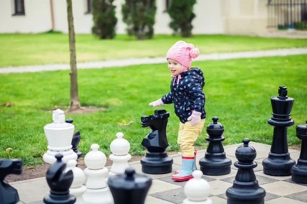 Дівчина грає з гігантськими шахами — стокове фото