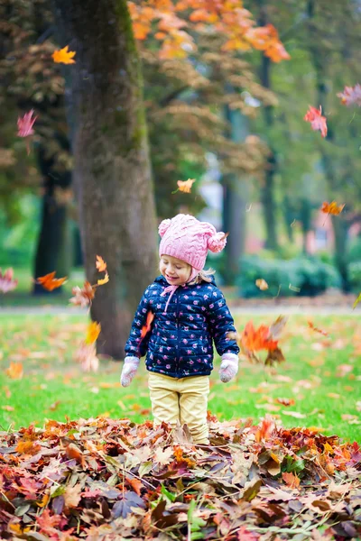 Heureuse petite fille jouer avec feuilles — Photo