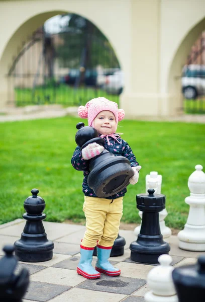 Kleines Mädchen nimmt einen Schachspieler — Stockfoto