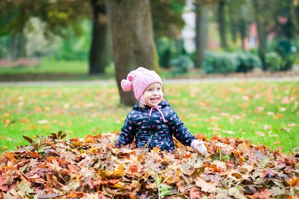 Skrattande flicka som leker i parken höst — Stockfoto