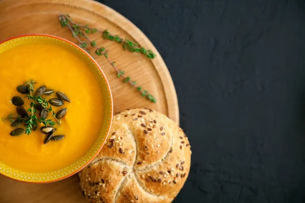 Close Homemade Pumpkin Soup Cheese Served Seeds Herbs Bun Black — Stock Photo, Image