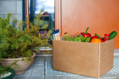 İçinde yemek olan bir apartman girişi. Temassız teslimat. Koronavirüs salgınının önleme tedbirleri.