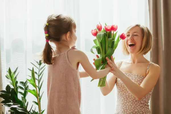 母亲节快乐 小女孩祝贺她的母亲 并送给她鲜花 妈妈和女儿在一起很开心专注于郁金香 — 图库照片