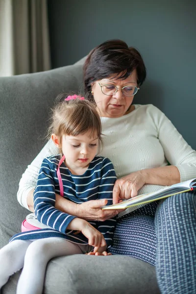 Бабуся Внучкою Обіймаються Читають Книгу Разом Бабуся Розповідає Казки Маленькій — стокове фото