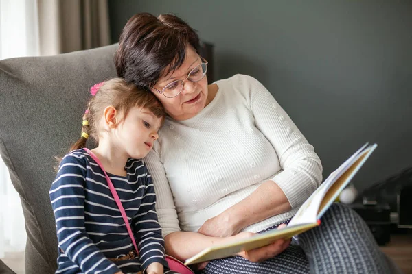 Loving Grandmother Reading Book Her Granddaughter Sitting Bean Bag Chair — Stock Photo, Image