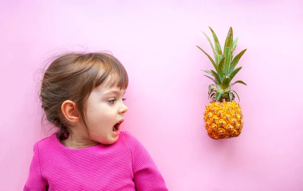 Niña Con Boca Abierta Mirando Mini Piña Sobre Fondo Rosa —  Fotos de Stock