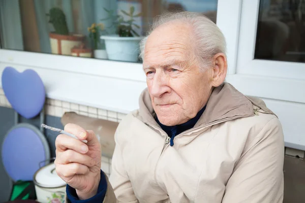 Old man holding a cigarette — Stock Photo, Image