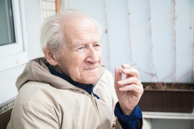 Yaşlı adam sigara içiyor.