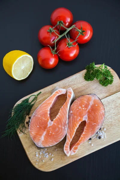 Bifes de salmão em uma tábua de madeira — Fotografia de Stock