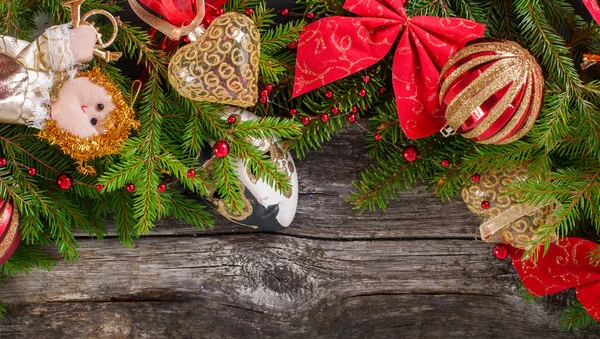 Spruce branches on the wooden background with golden hearts — Stock Photo, Image