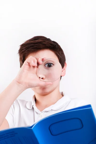 Boy looks at through a magnifying glass — Stock Photo, Image