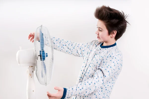 Мальчик рядом с вентилятором — стоковое фото