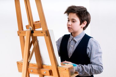 Sanatçı okul çocuk boyama fırça suluboya portre bir şövale üzerinde