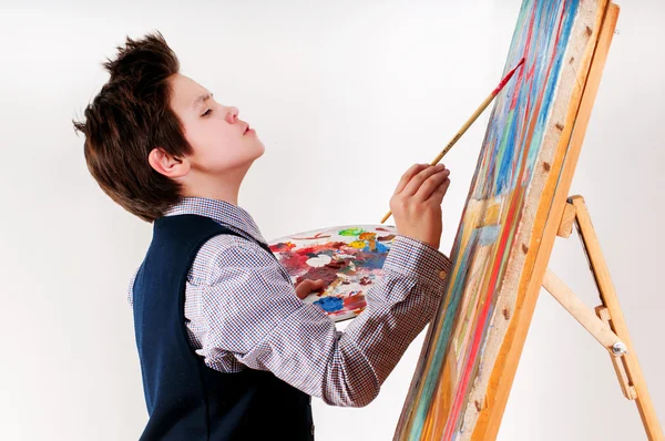 Kunstenaar school jongen schilderij borstel aquarellen portret op een ezel — Stockfoto