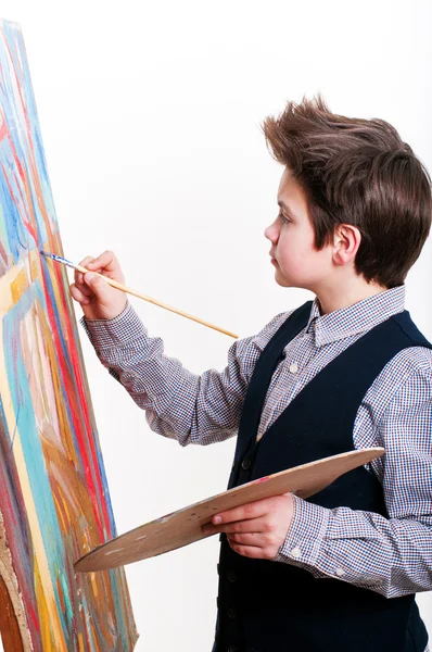 Kunstenaar school jongen schilderij borstel aquarellen portret op een ezel — Stockfoto