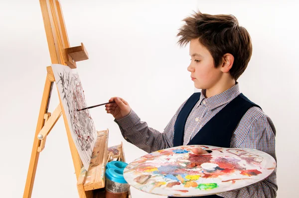 Мальчик-художник рисовал акварель на мольберте — стоковое фото