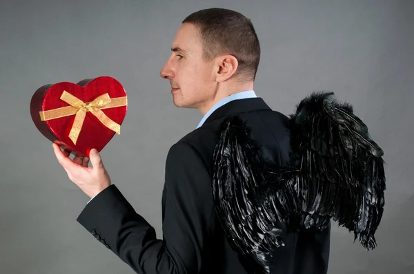 Man in wings with red heart — Stock Photo, Image