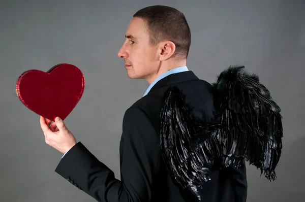 Man in wings with red heart — Stock Photo, Image