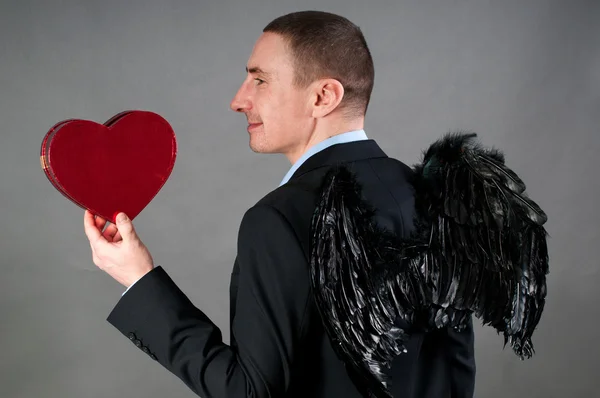 Muž v křídla s červeným srdcem — Stock fotografie