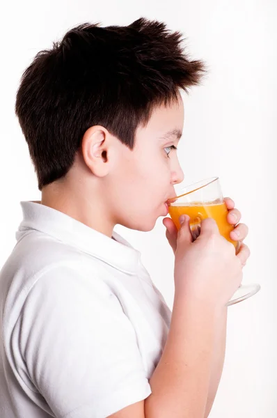 Chlapec pije pomerančovou šťávu — Stock fotografie