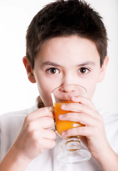 Boy drinks orange juice — Stock Photo, Image