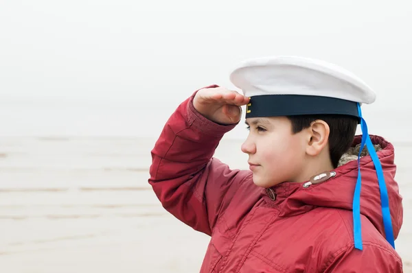 Garçon dans une casquette haute du garçon cabine de la mer — Photo