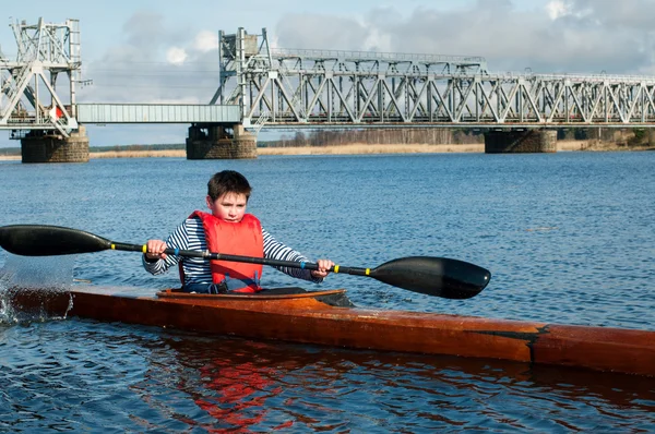 The boy rowing in a kayak on the river — Stock Photo, Image
