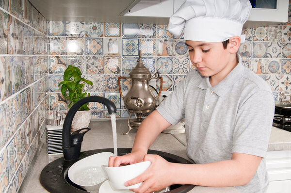 Boy washing dishes