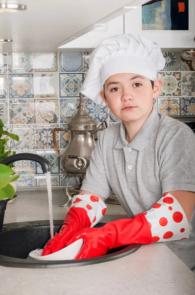 Junge spült Geschirr Stockfoto