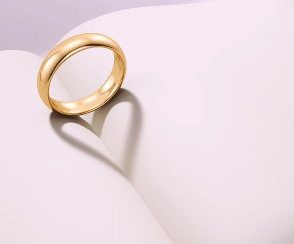 Wedding ring casting heart shaped shadow — Stock Photo, Image