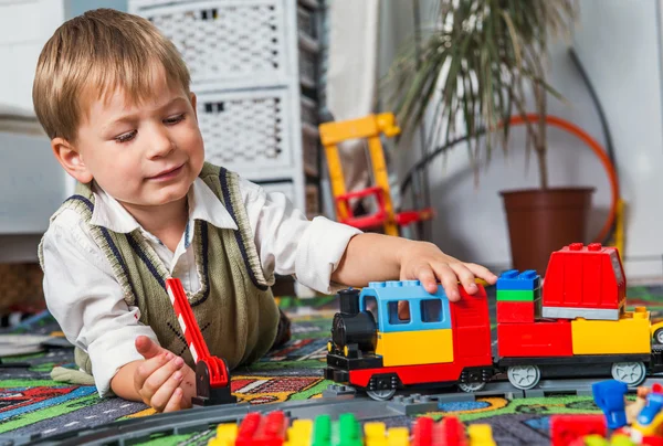 Menino está brincando com um trem — Fotografia de Stock