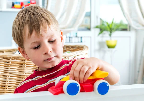 Bambino gioca gioco da tavolo con le auto — Foto Stock