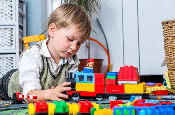 Little boy is playing with a train — Stock Photo, Image