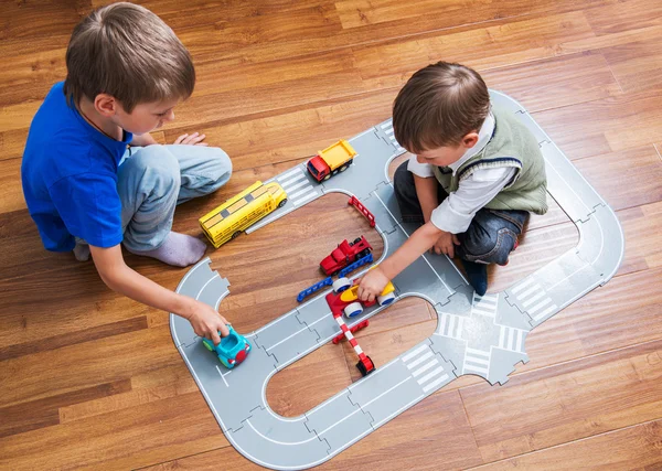 Dos niños pequeños juegan con coche de juguete —  Fotos de Stock