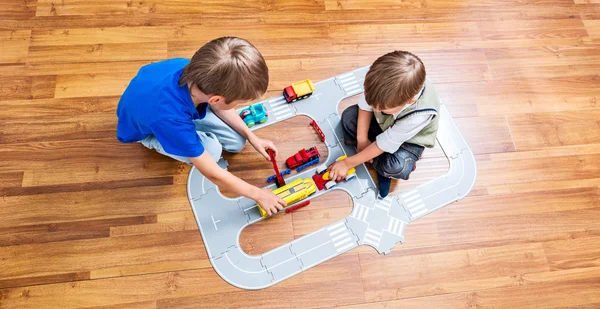 Dos niños pequeños juegan con coche de juguete —  Fotos de Stock