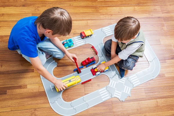 Dos niños pequeños juegan con coche de juguete —  Fotos de Stock