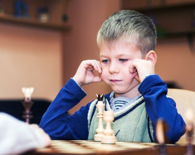 Little boy playing chess clipart