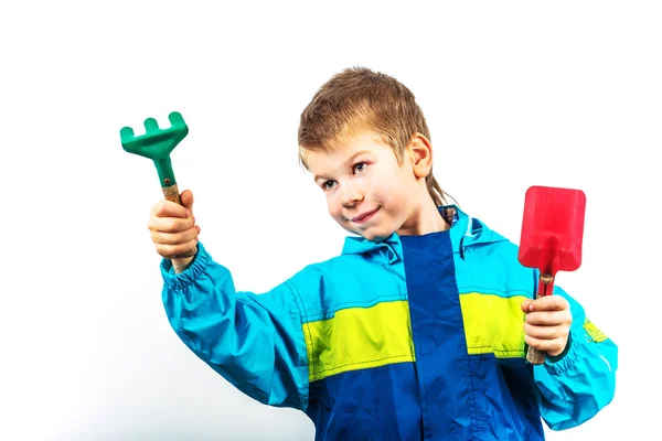 Feliz niño de la jardinería de primavera con pala y rastrillo —  Fotos de Stock