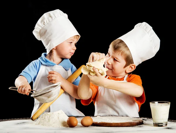 İki küçük çocuk yapma pizza veya makarna hamur. Siyah izole — Stok fotoğraf