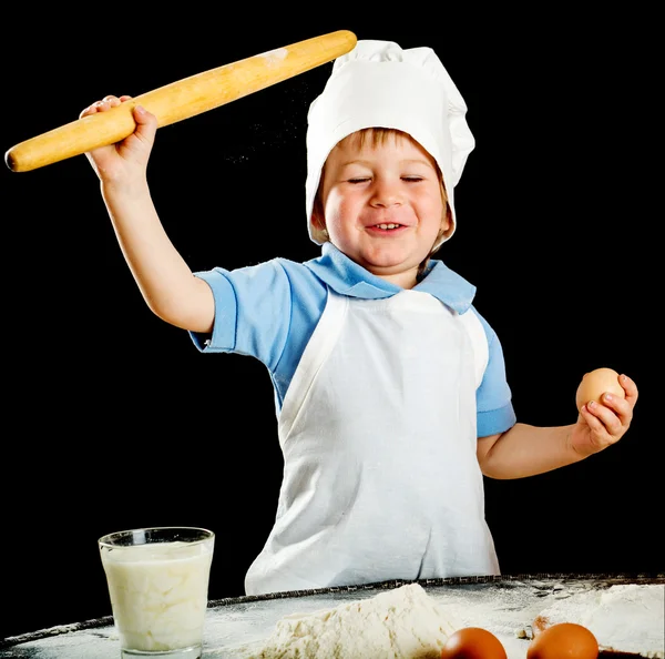 Μικρό αγόρι κάνοντας πίτσα ή ζυμαρικά ζύμη. Απομονώνονται σε μαύρο. — Φωτογραφία Αρχείου