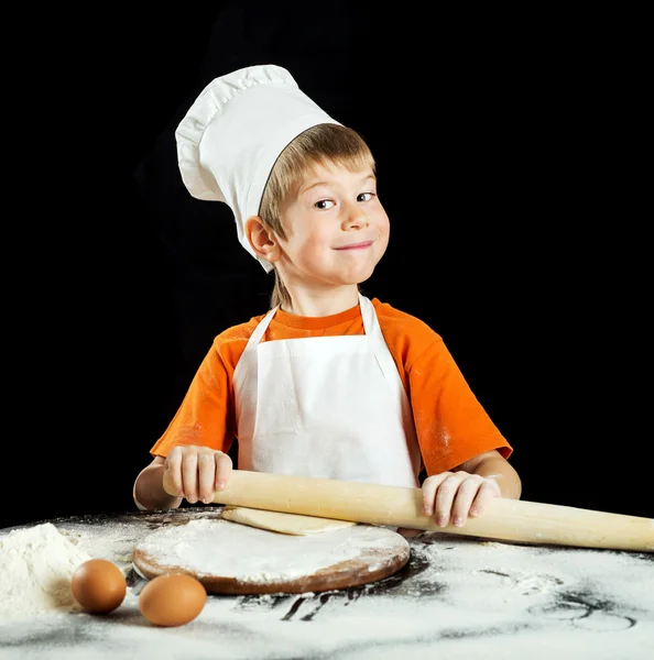 Anak kecil membuat pizza atau adonan pasta. Terisolasi di atas hitam . — Stok Foto